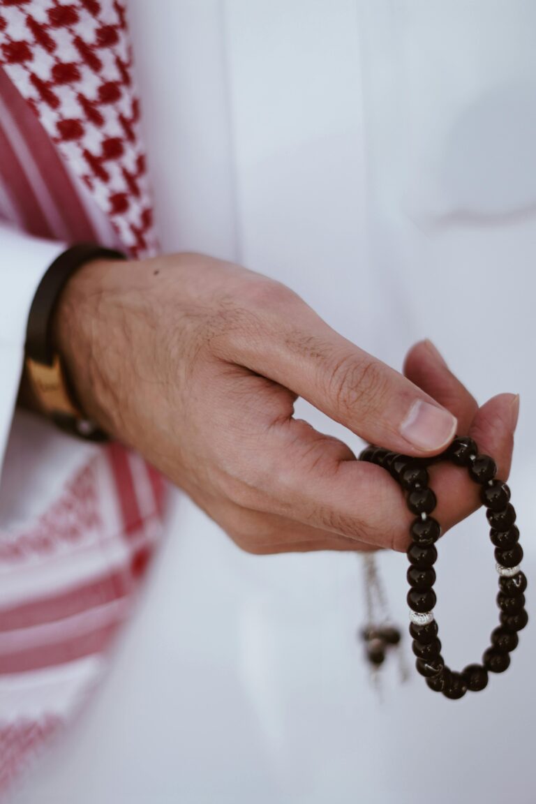 A man holding Islamic prayer beads, emphasizing devotion and spirituality.